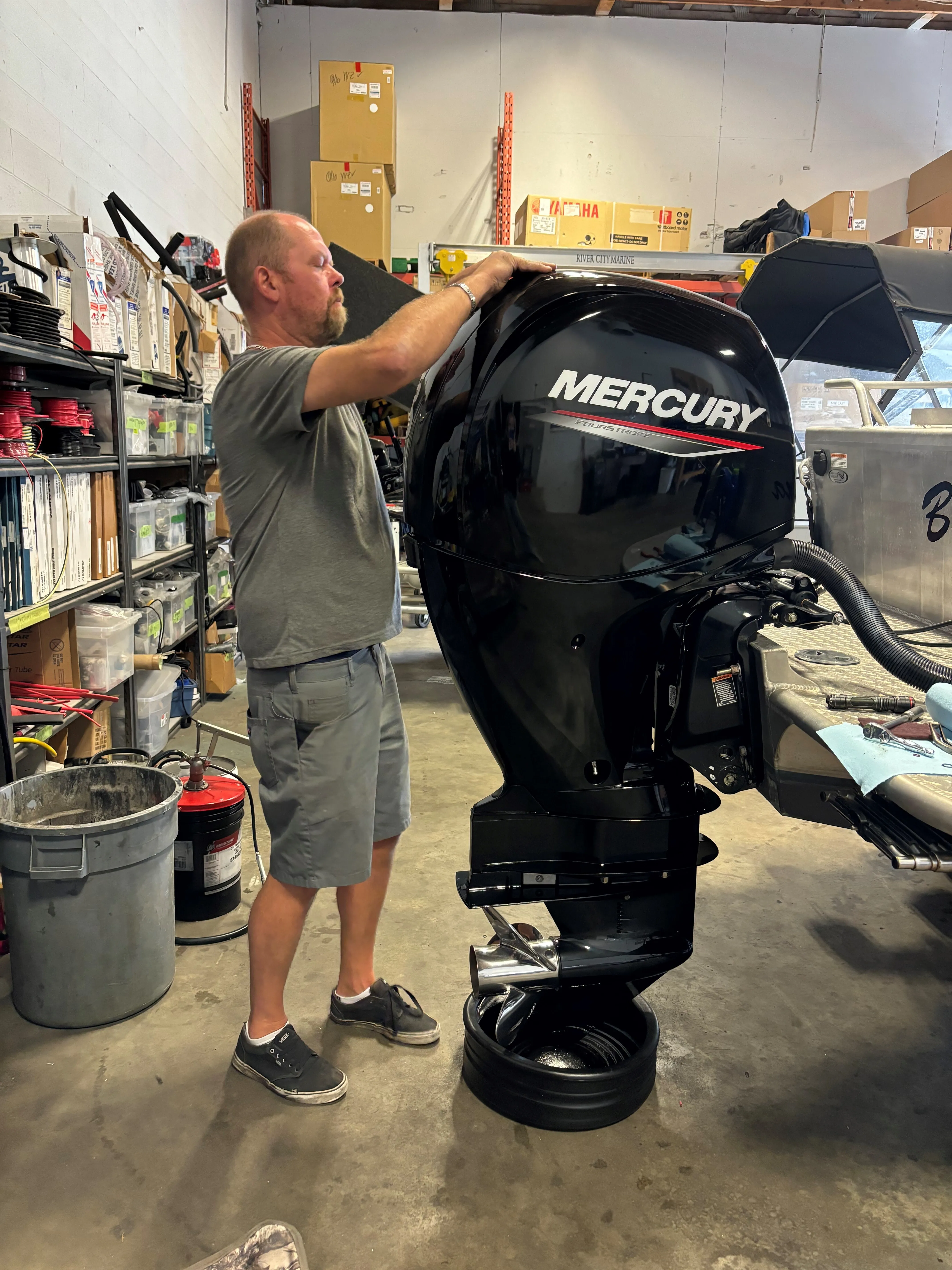 A man work with black mercury outboard motor | River City Marine